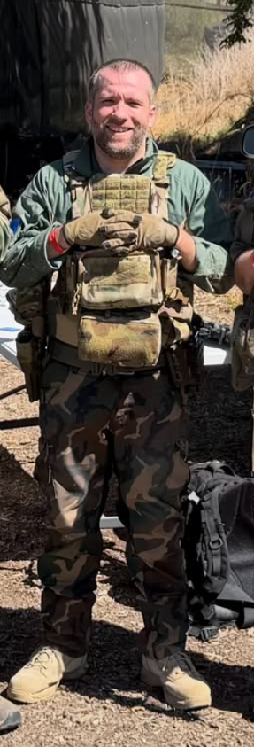 Keaton of Mike Force Irregulars in woodland camo and plate carrier at an airsoft field